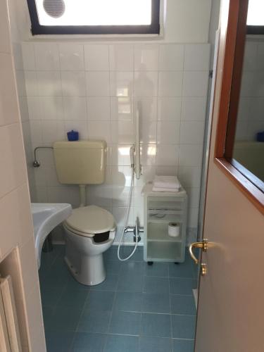 a small bathroom with a toilet and a sink at Vicolo del Pozzo in Barolo