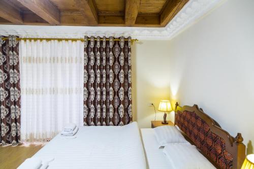 a bedroom with two beds and a window at Hotel Volida Boutique in Bukhara