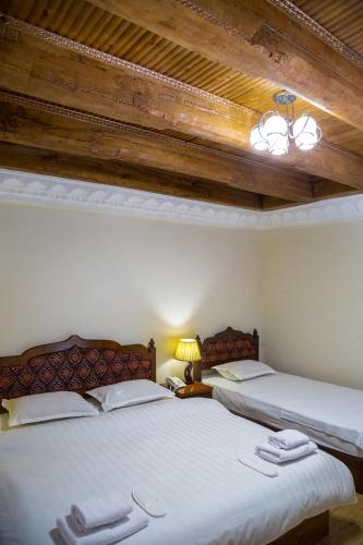 two beds sitting next to each other in a bedroom at Hotel Volida Boutique in Bukhara