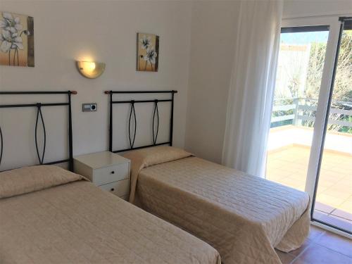 2 bedden in een kamer met een balkon bij Villa Emilia, Terraces & Pool in Sant Martí d’Empúries