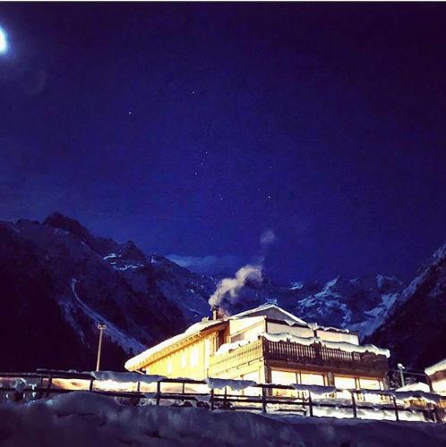 a building with smoke coming out of it at night at La Tana dell'orso Hotel & SPA in Ponte di Legno