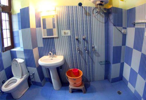 a bathroom with a sink and a toilet and a shower at Hotel Aroma Classic in Kulu