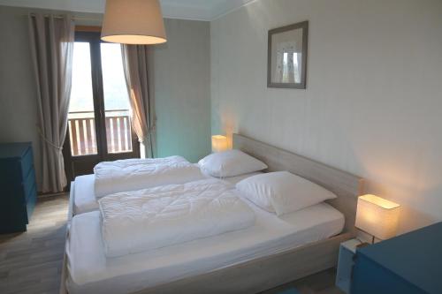 a bedroom with a bed with white sheets and pillows at Chalet Beau Regard in Hellert