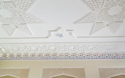 a white room with a white ceiling with patterns at Hotel Volida Boutique in Bukhara