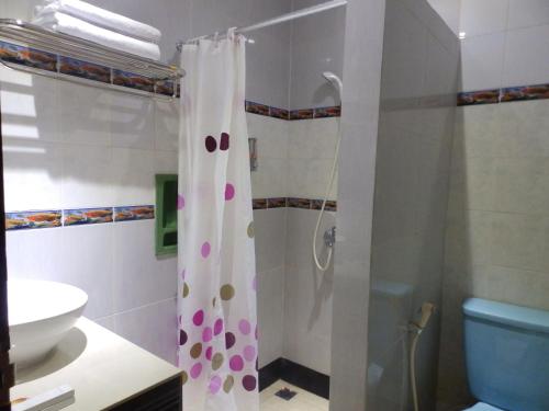 a bathroom with a shower with a shower curtain at Bahari Family Hotel in Bitung