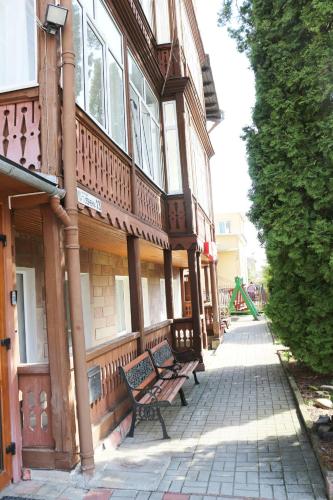 a wooden building with two benches in front of it at Сонячна in Truskavets