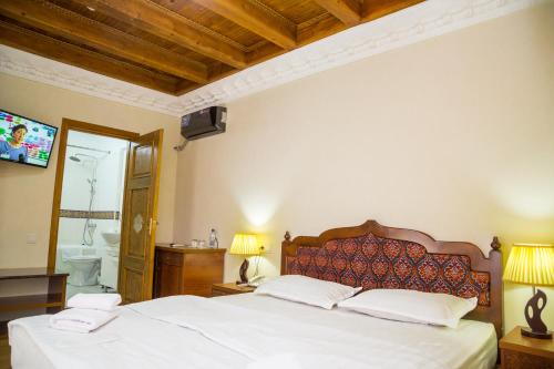 a bedroom with a large bed and a bathroom at Hotel Volida Boutique in Bukhara