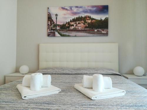維洛納的住宿－A casa di Luca，一间卧室配有带2条白色毛巾的床