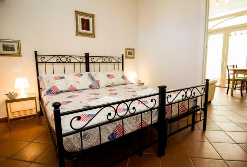 Schlafzimmer mit einem Bett mit schwarzem Rahmen in der Unterkunft La Torre Holiday House in Pisa