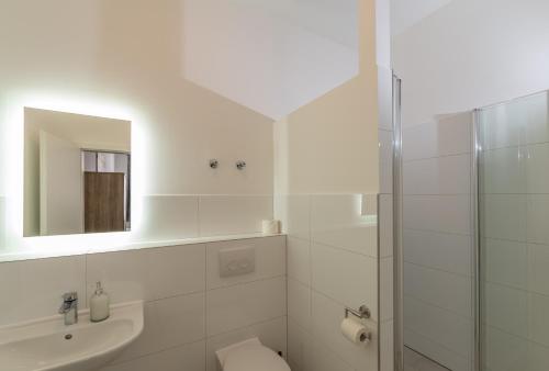 a bathroom with a sink and a toilet and a mirror at Boutique-Hotel Kronenstuben in Ludwigsburg