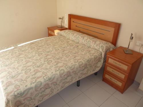 a small bedroom with a bed and a night stand at Playa Golf in Benalmádena