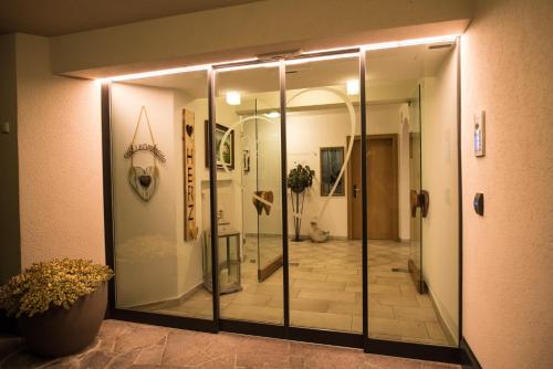 a walk in shower with a glass door in a room at Hotel Garni Herz in Tirolo