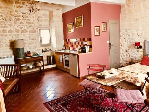 a kitchen with red walls and a table and chairs at Le trente trois in Uzès