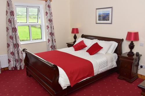 Un dormitorio con una cama con sábanas rojas y blancas y una ventana. en An Bothar Pub, en Brandon Creek