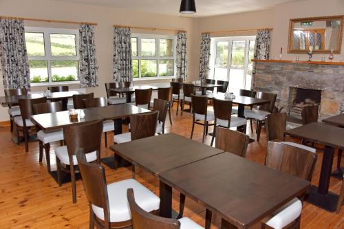 a restaurant with tables and chairs and a fireplace at An Bothar Pub in Brandon Creek