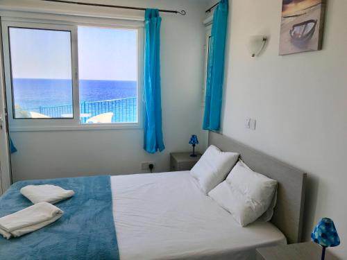a bedroom with a bed with a view of the ocean at A.A Michael Apartments in Pachyammos