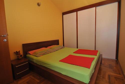 1 dormitorio con 1 cama con 2 toallas rojas en Rossa Apartments, en Budva