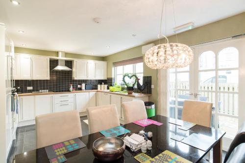 a kitchen with a dining table and a chandelier at Maes Bach Boutique GUEST HOUSE TOWN CENTRE in Aberystwyth