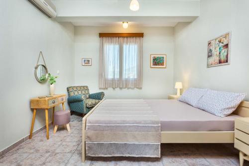 YerakiníにあるGerakini Sunshine Holiday Homesのベッドルーム(大型ベッド1台、椅子付)