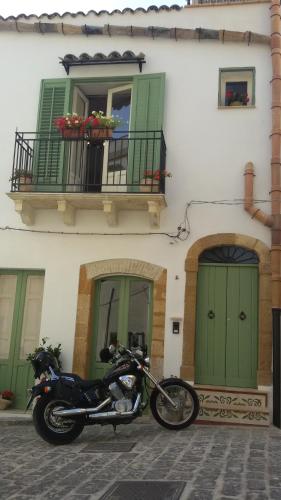 motocykl zaparkowany przed budynkiem z zielonymi drzwiami w obiekcie Le Stanze dell'Emiro w mieście Sambuca di Sicilia