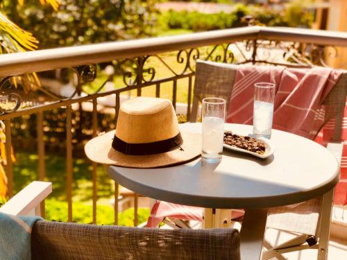 a hat and glasses on a table on a balcony at G George in Nydri