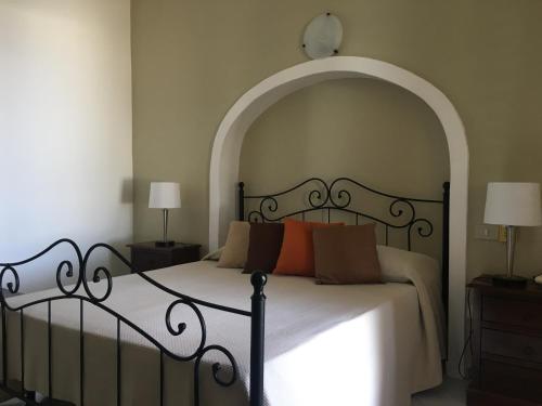 a bedroom with a large bed with an archway at Hotel O Palmo in Panarea