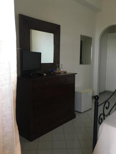 a bedroom with a dresser with a television on it at Hotel O Palmo in Panarea