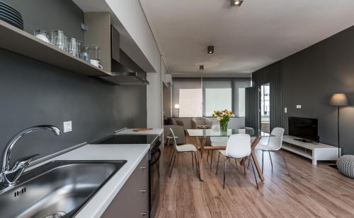 アテネにあるAthens City Center Apartmentのテーブルと椅子のあるキッチンとダイニングルーム