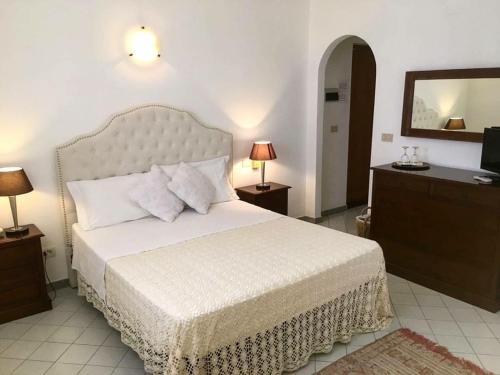 a bedroom with a bed and a dresser and a television at Hotel O Palmo in Panarea