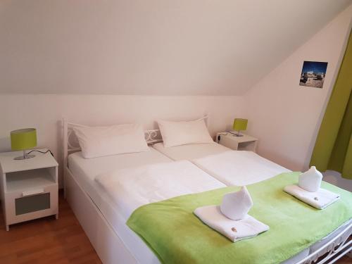 um quarto com uma grande cama branca com toalhas em Ferienwohnung Nordwind em Cuxhaven