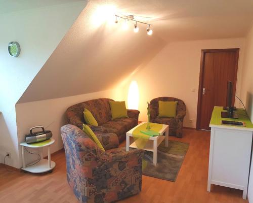 uma sala de estar com dois sofás e uma televisão em Ferienwohnung Nordwind em Cuxhaven