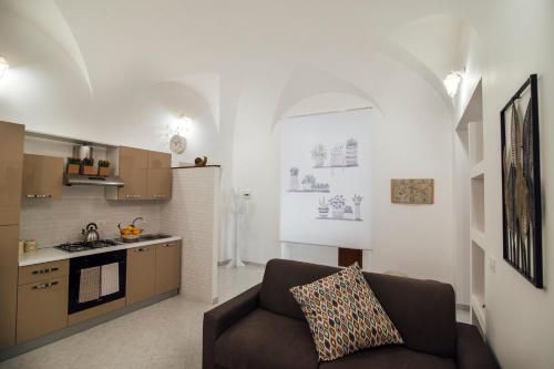 ein Wohnzimmer mit einem Sofa und einer Küche in der Unterkunft Via Vittorio Emanuele Apartment in Palermo