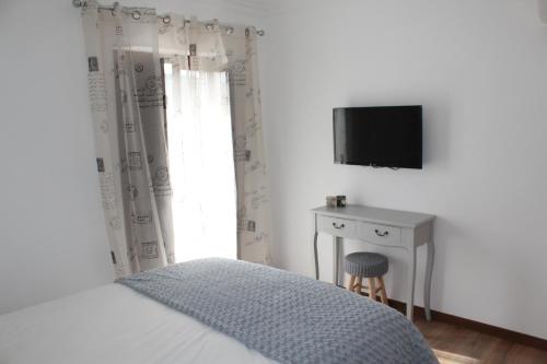 um quarto com uma cama, uma escrivaninha e uma televiso em Meimoa Guesthouse em Meimoa