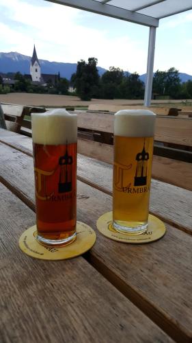 フィラッハにあるGastehaus Melcherの木製テーブルの上に座るビール2杯