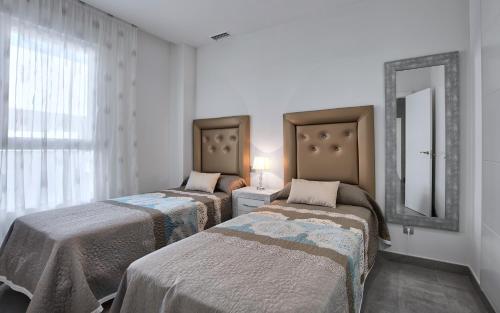 two beds in a room with a mirror and a mirror at La Reserva Puerto Banus in Marbella