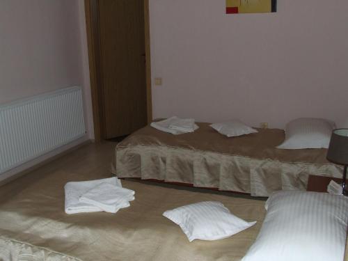 two beds in a room with towels on the floor at Pensiunea Caramell in Cluj-Napoca