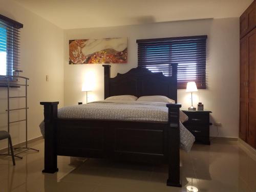 um quarto com uma cama e dois candeeiros e um quadro em Little Live in Harmony - Santiago em Santiago de los Caballeros