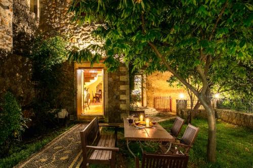 a table and chairs under a tree in a yard at Ifigenia Theriso Village in Thérison