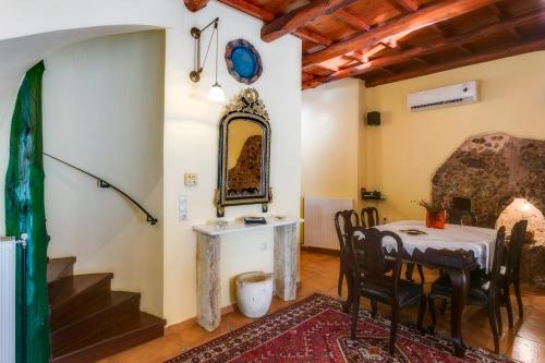 a dining room with a table and chairs and a mirror at Ifigenia Theriso Village in Thérison