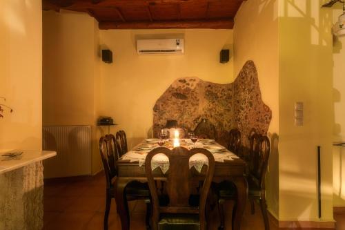 a dining room with a table with a candle on it at Ifigenia Theriso Village in Thérison
