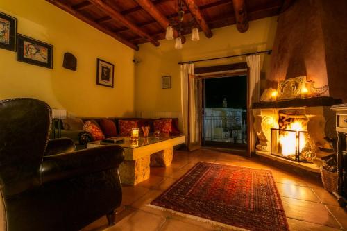 a living room with a couch and a fireplace at Ifigenia Theriso Village in Thérison
