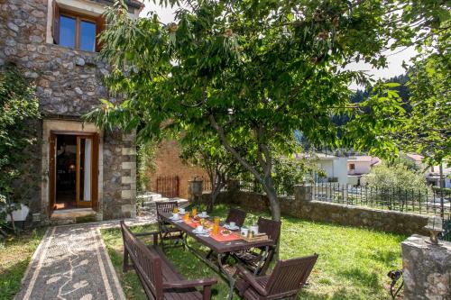 a table and chairs in the yard of a house at Ifigenia Theriso Village in Thérison