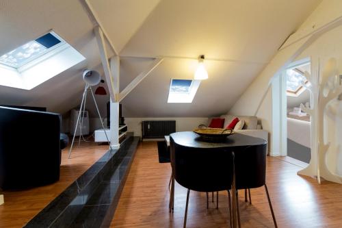 a room with a table and chairs in a attic at The Queen Luxury Apartments - Villa Carlotta in Luxembourg
