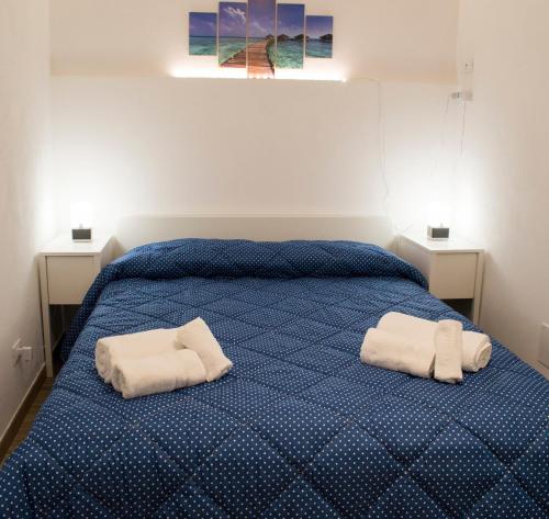 a bedroom with a blue bed with two towels on it at Casetta Maremè in San Vito lo Capo