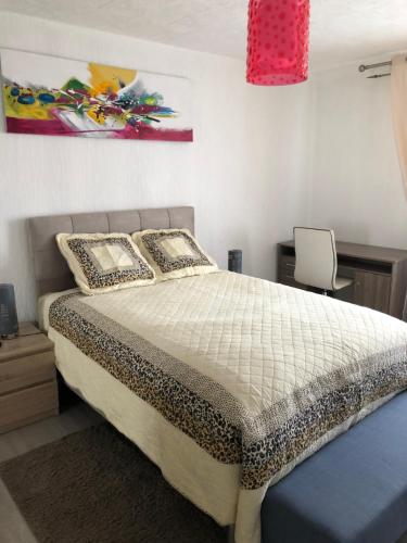 a bedroom with a large bed and a chair at Les Charmantes in Cernay