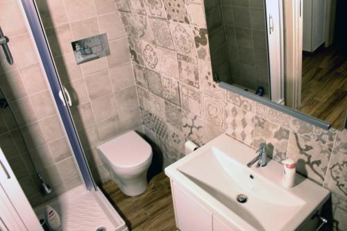 a bathroom with a sink and a toilet and a mirror at Casetta Maremè in San Vito lo Capo