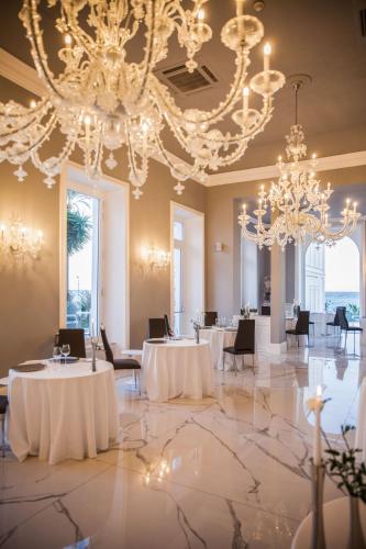 a banquet hall with white tables and chandeliers at Miramare The Palace Resort in Sanremo