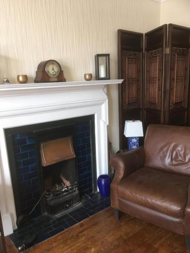 a living room with a couch and a fireplace at Elmdon Lodge in Birmingham