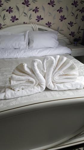 ein Bett mit weißen Decken und Kissen darauf in der Unterkunft Apartament Matei in Constanţa