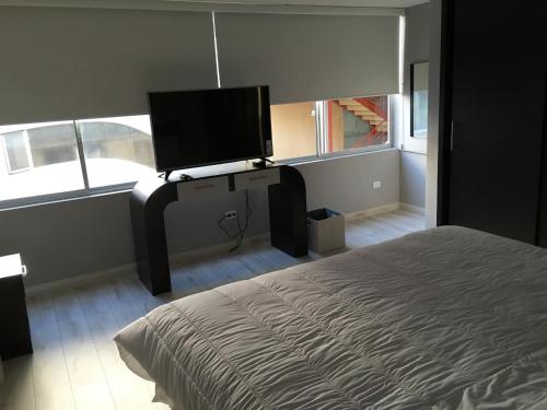 1 dormitorio con 1 cama y TV de pantalla plana en Edificio Tofino, en Quito